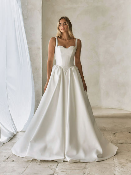 Full front view of the Serene Teddy wedding dress in luxe Mikado, featuring square-neck bodice, layered sweetheart bust detail, Basque waist illusion, and full A-line skirt with long train.