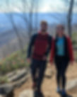 A couple hiking on a trail behind the Lovill House Inn