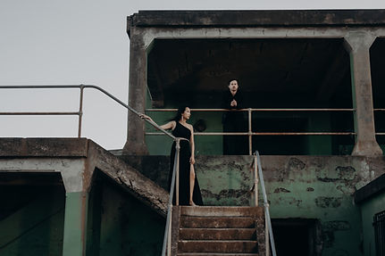 vogue cover style image of couple in black tie in old military bunker