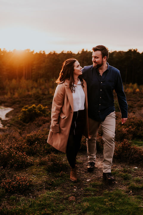 Couple walking together at sunset at Frensham Ponds.