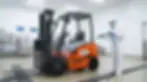 Opérateur en combinaison blanche de protection lavant un chariot élévateur VMAX IP65 au jet haute pression en zone de lavage alimentaire — composants étanches pour nettoyage quotidien