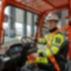 Cariste VMAX en cabine de chariot élévateur avec ceinture de sécurité orange attachée — toit FOPS avec inscription Sécurité Obligatoire - Attacher Ceinture visible au-dessus