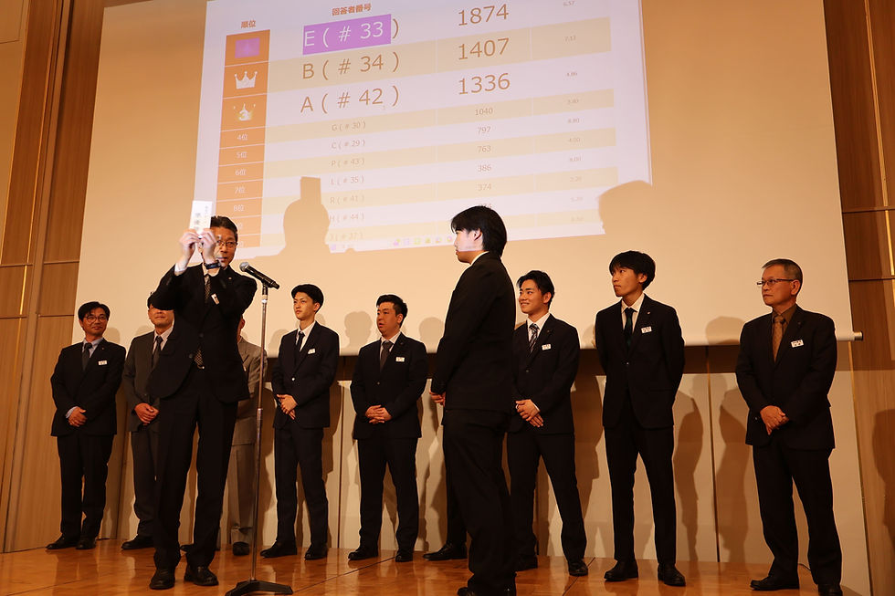 懇親会の余興で点数の高いチームがステージで賞金をもらっている