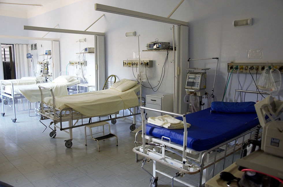 Large empty hospital room with beds and equipment