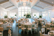 Elegant wedding reception venue decorated with tables, chairs, and floral arrangements.
