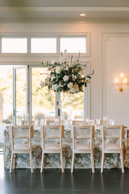Elegant wedding reception table setting with floral centerpiece and soft natural lighting