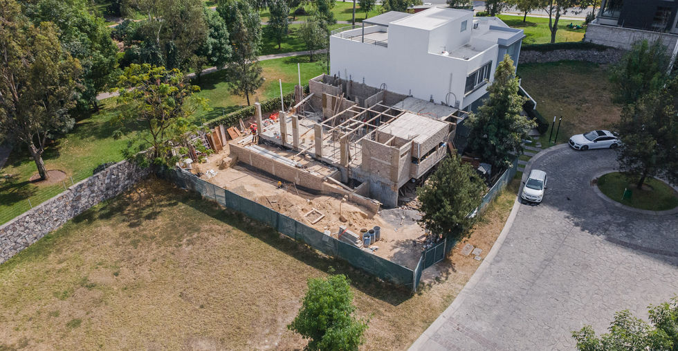 Vista en construcción de casa en Puerta Las Lomas, Zapopan, con cimentación y estructura avanzada.