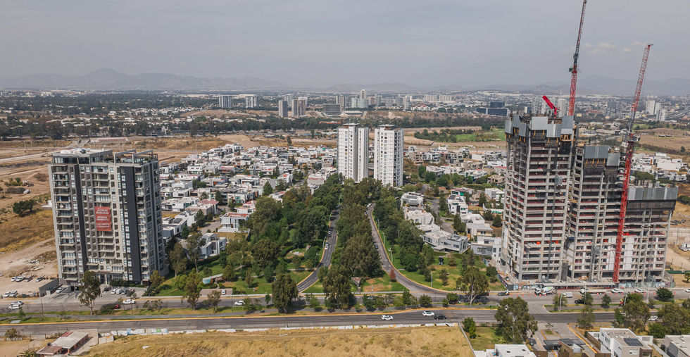 Vista aérea del fraccionamiento Puerta Las Lomas en Zapopan, rodeado de áreas verdes y desarrollos residenciales de lujo.