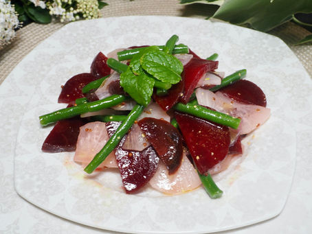 Beetroot an daikon  salad with green beans and mint on a decorative white plate. Floral background, light and fresh ambiance.