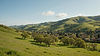 wide_landscape_photograph_of_a_green_east_bay_valley_in_spring_with_rolling_hills_clusters