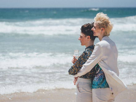 Midday elopement at Kingscliff Beach with two brides sharing candid, emotional moments by the shore.
