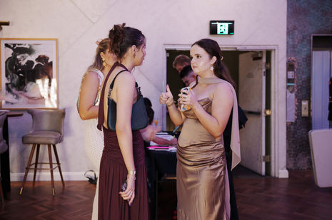 Candid and posed moments from a formal ball, with groups dressed in suits and gowns celebrating on the dance floor and around the venue.