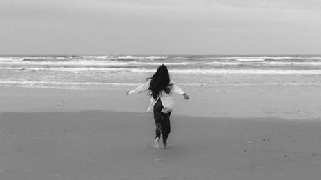 Moody portrait of a South Asian woman in a white Witchery shirt on Miami Beach, captured with soft, cinematic light.
