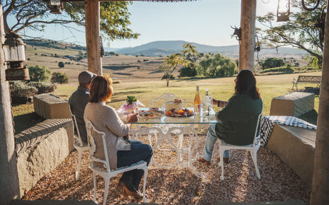 Golden hour family portrait session at Milford Cottages Boonah featuring a multi-generational family in a rustic field.