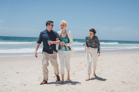 Midday elopement at Kingscliff Beach with two brides sharing candid, emotional moments by the shore.
