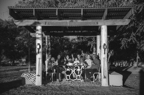 Golden hour family portrait session at Milford Cottages Boonah featuring a multi-generational family in a rustic field.