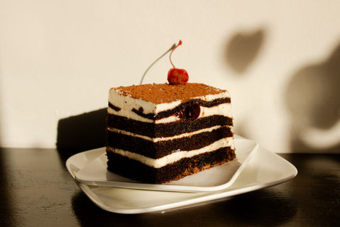 Black Forest Cake.
Multiple layers of chocolate cake and chantilly cream with cherries. topped with cacao power and a maraschino cherry.