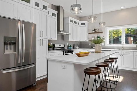 white cabinets kitchen with granite top island that is beautifully staged