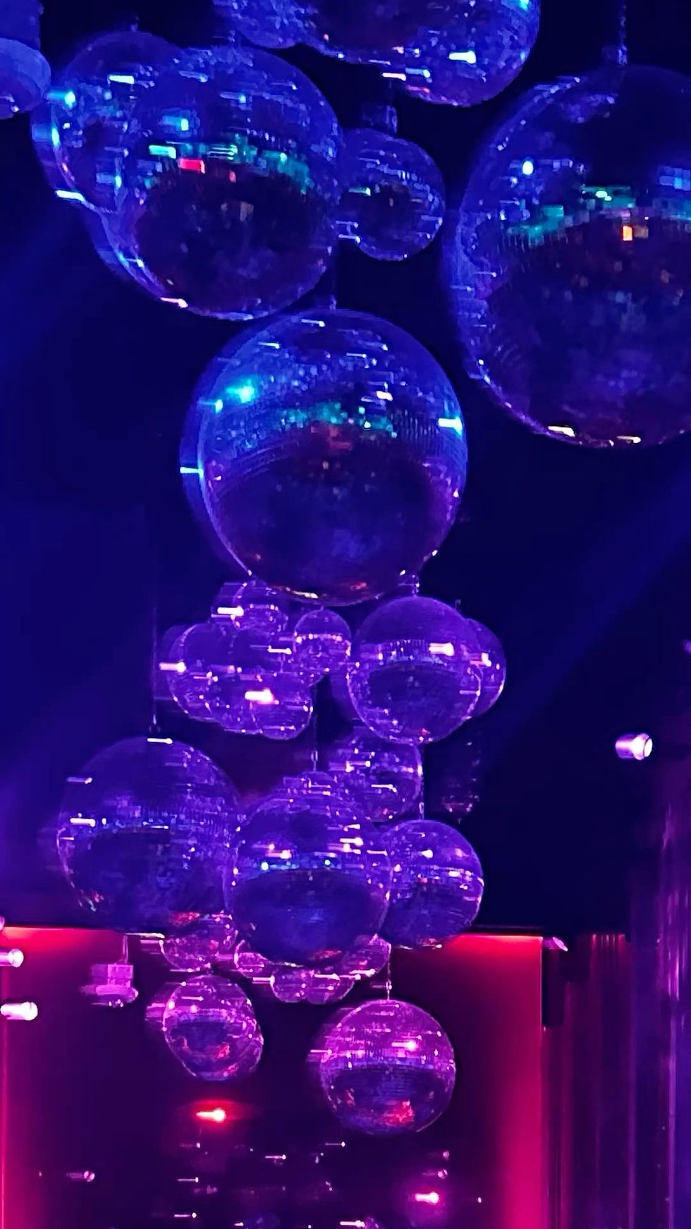Hanging glass spheres under blue and purple lighting