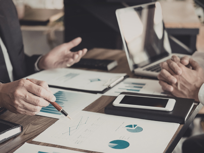 Business professionals reviewing charts and documents at a meeting table