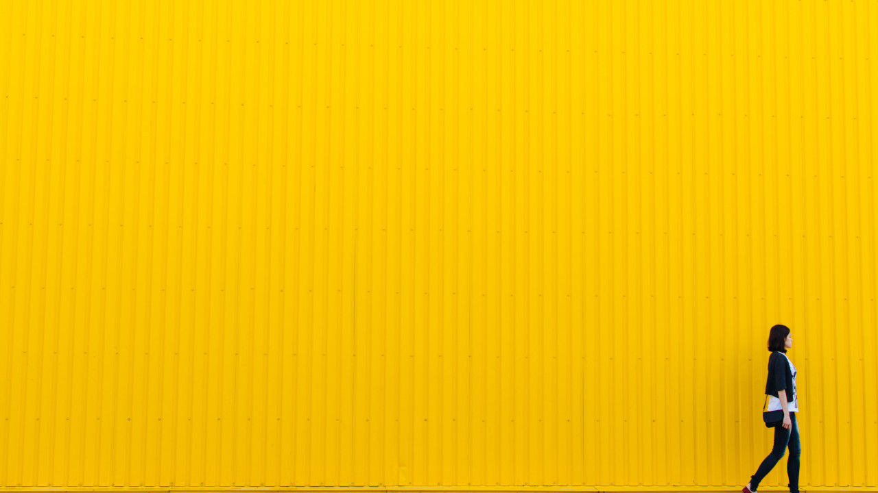 woman walking along a yellow container