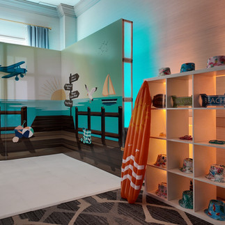 Interactive event photo booth featuring themed backdrop artwork and display cubbies with decorative props, styled for a boardwalk-inspired celebration.