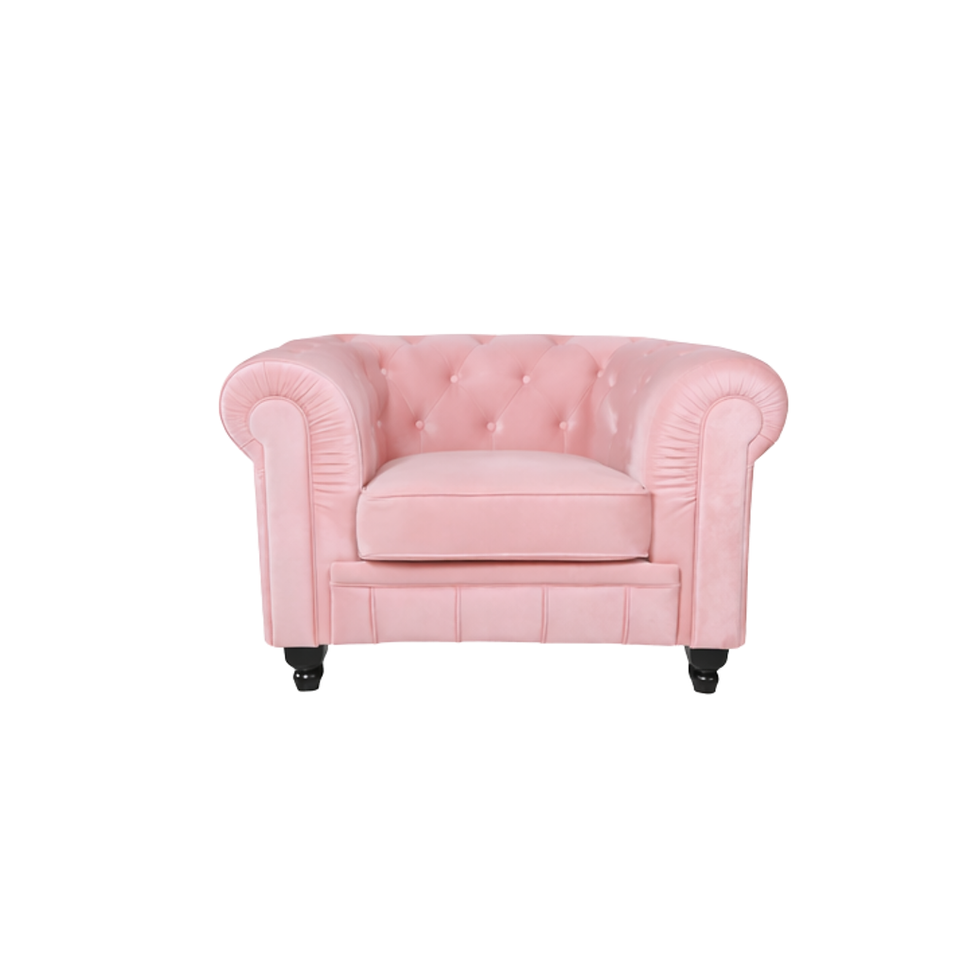 Soft pink velvet Chesterfield lounge chair with deep button tufting, rolled arms, and a classic silhouette.