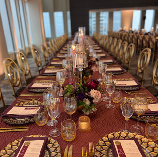 Elegant place setting with gold leaf charger, custom menu, and plum linen napkin for a luxury birthd