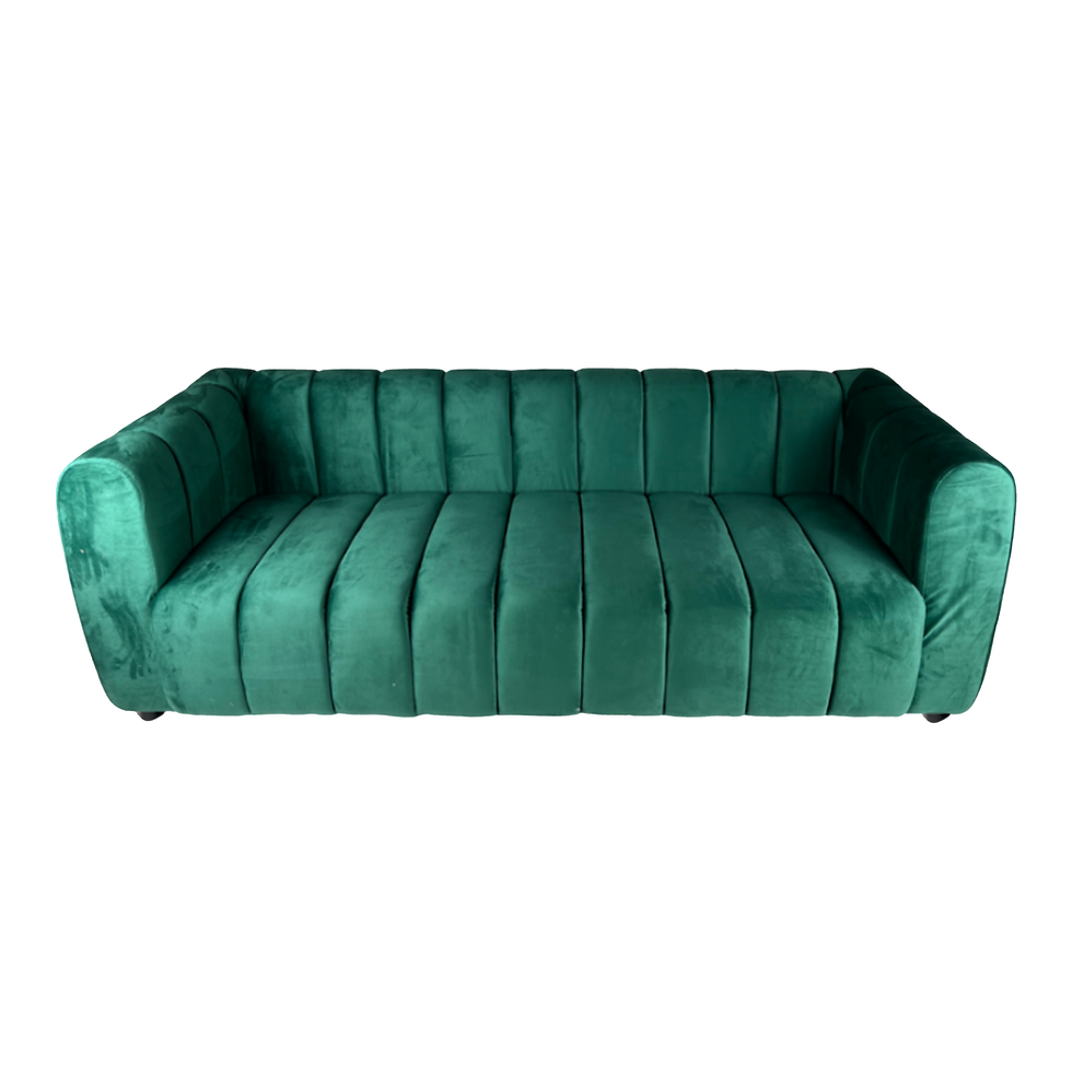 Emerald green velvet sofa with vertical channel tufting, rounded arms, and a sculptural contemporary silhouette.