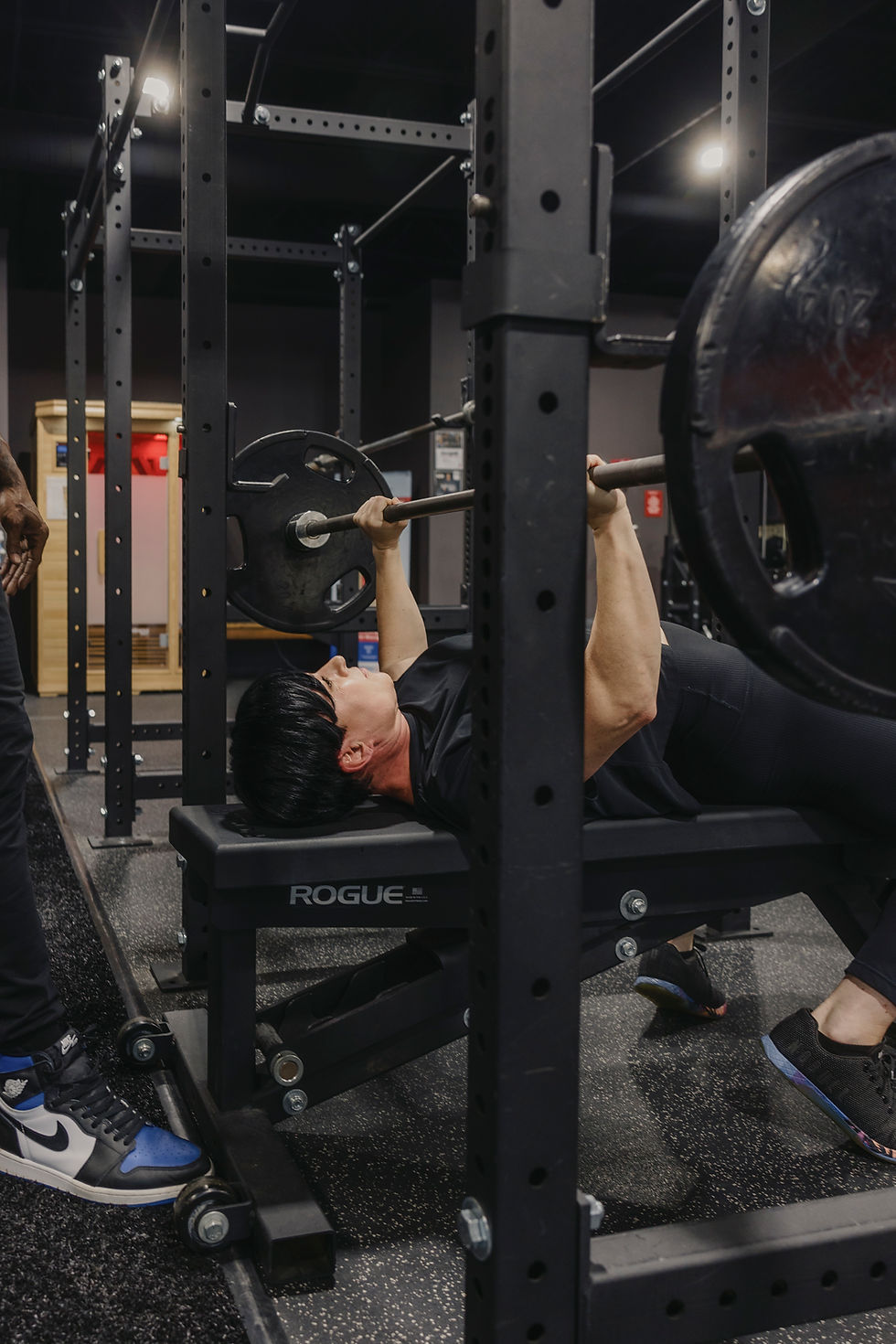 Personal trainer Newnan GA spotting a man's bench press.