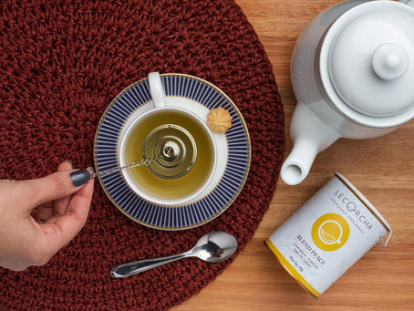 um delicioso chá sendo na xícara sendo infuionado, ao lado tem um bule e a embalagem do chá da lecorchá.