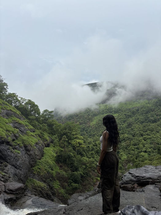 A woman standing in a misty natural landscape on a cloudy morning in Rwanda