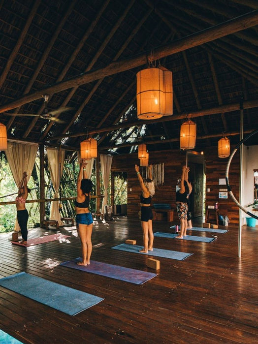  Women doing indoor yoga in a calm and peaceful space in Rwanda