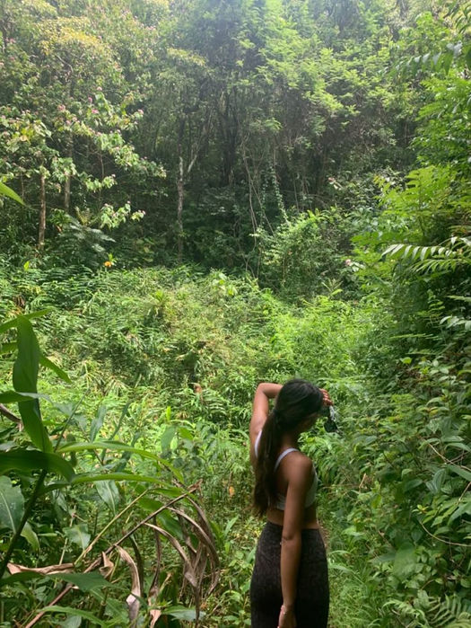 A woman standing peacefully in nature during the Journey to Reconnect and Rise women-only retreat in Rwanda in Musanze