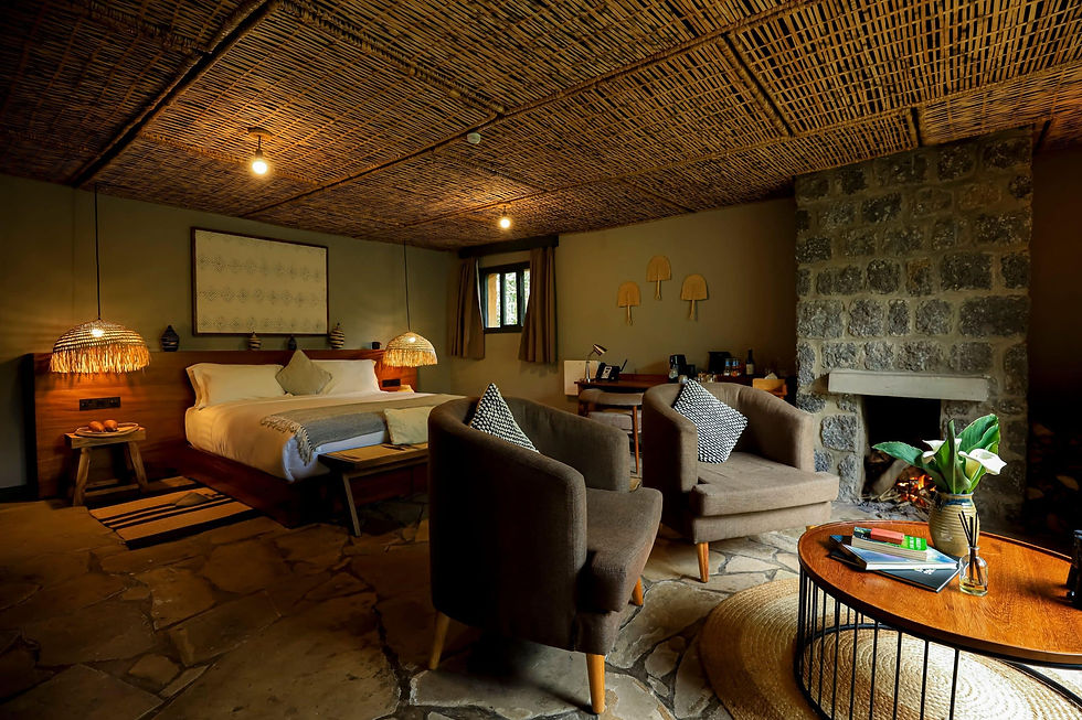 Interior view of a guest room at Sambora Kinigi Hotel showing furnishings and window views of the surrounding landscape