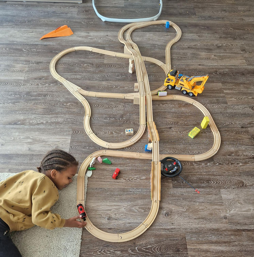 little boy playing with a train track