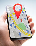 Close-up Of A Person's Hand Holding Cellphone With Red Map Pin Pointer Against White Backg