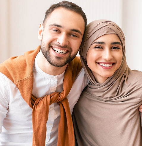 Happy Muslim Couple Embracing Sitting Together On Couch At Home.jpg
