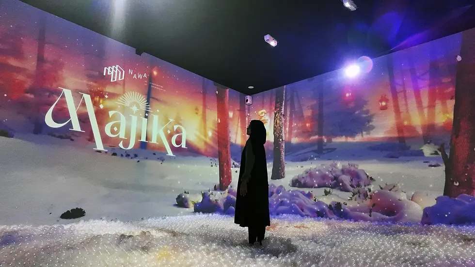 Seseorang wanita sedang berdiri ditengah visual video mapping hutan dengan tulisan Nawa Majika
