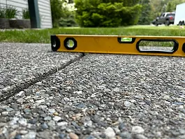 A level placed on a repaired concrete slab after leveling, showing an even surface following concrete leveling work by Level Best Northwest