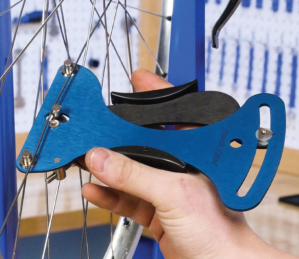 A blue tensiometer tool, which squeezes a spoke and shows the tension on a dial at the end.