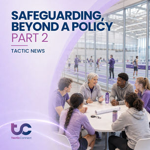 Coach talks to five athletes at a round table, discussing safeguarding policies and proceedures. They're in a sports facility with purple attire and water bottles.
