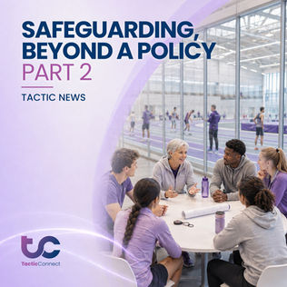 Coach talks to five athletes at a round table, discussing safeguarding policies and proceedures. They're in a sports facility with purple attire and water bottles.