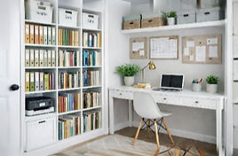 A home office, representative of a small business. Showing a desk, computer, notice board, time planner, files, printer, book shelves and storage boxes.