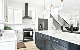 Sleek kitchen design with pendant lighting, white cabinets, and wood accents
