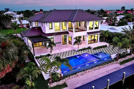 Aerial twilight shot of luxury home with pool and palm trees in Sarasota