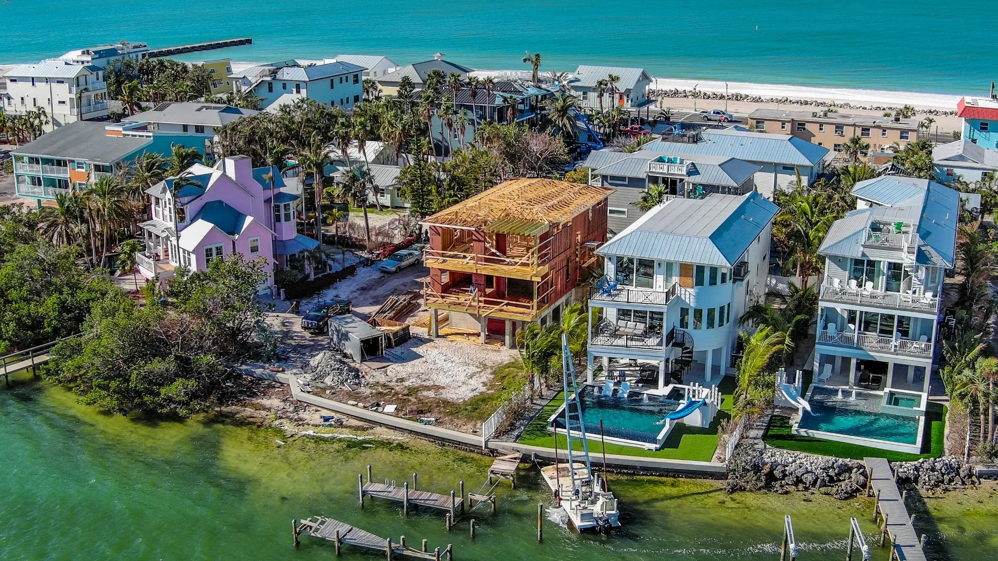 Aerial drone photo of a waterfront home with a pool near the Gulf Coast