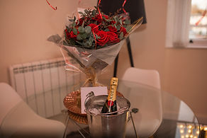 Hotel Room Surprise Proposal by The Cotswold Proposal Planners in the Hideaway Shepherds Huts at Cheltenham Airbnb Cotswolds Champagne Moet engaged balloons and bouquet of flowers