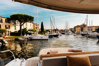 Tourists at the back of a yacht leaving Port Grimaud Marina on the Riviera