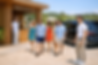 Stylish group arriving at Tropicana Beach, stepping out of a luxury van into a chic seasid